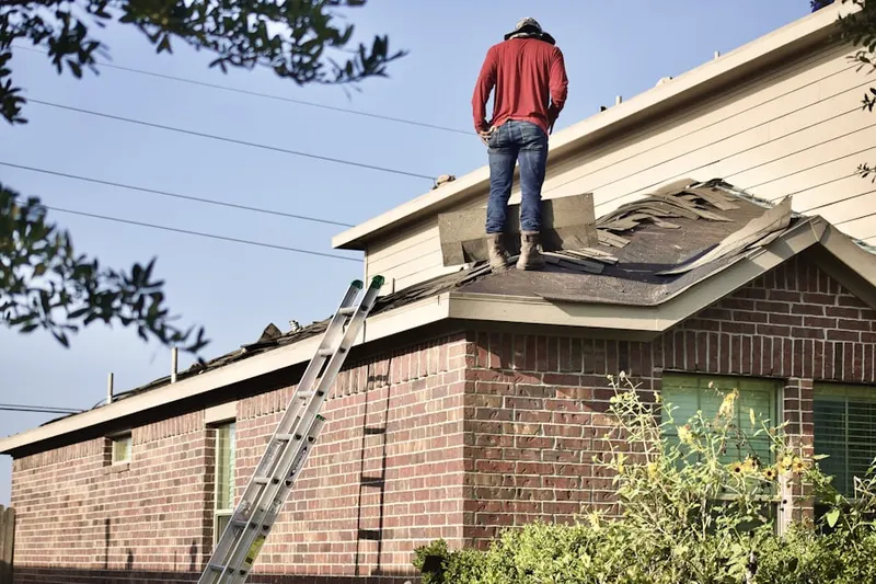 Professional roofer working on a residential roof in Carlton Stewart Gardens